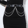 Minifalda negra combinada con un cinturón de cadena de cuero negro con hebillas en forma de corazón y cadenas de plata
