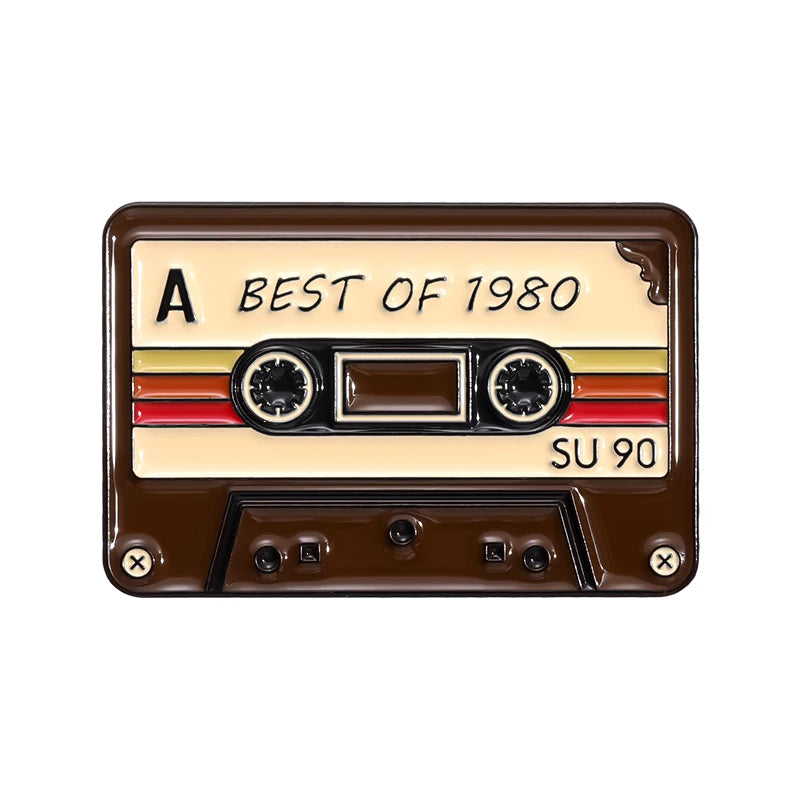 Broche émail vintage avec le texte BEST OF 1980 sur fond rectangulaire marron et deux éléments circulaires.