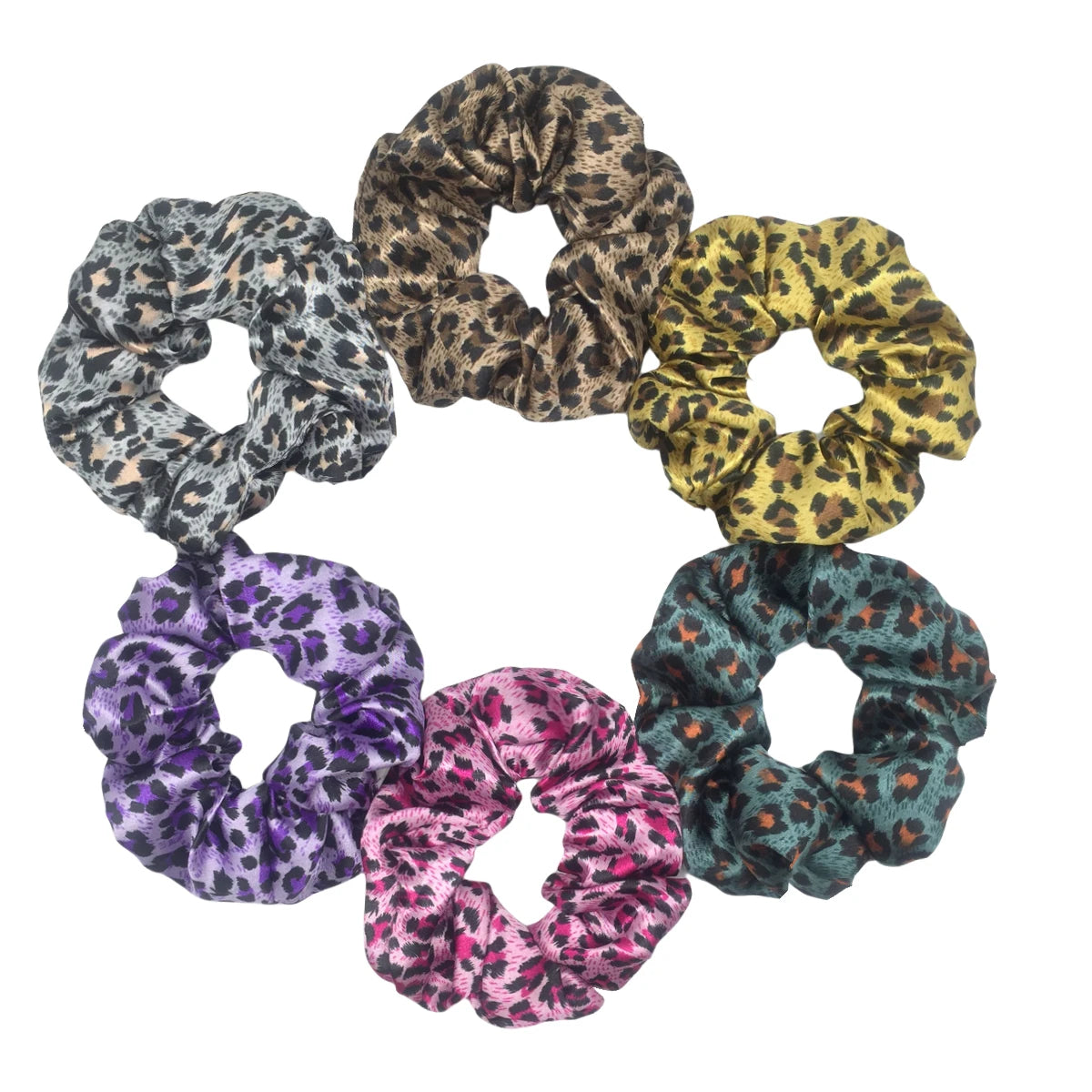 Un set de seis gomas para el pelo de satén con estampado floral en varios patrones de leopardo y florales, dispuestos en círc