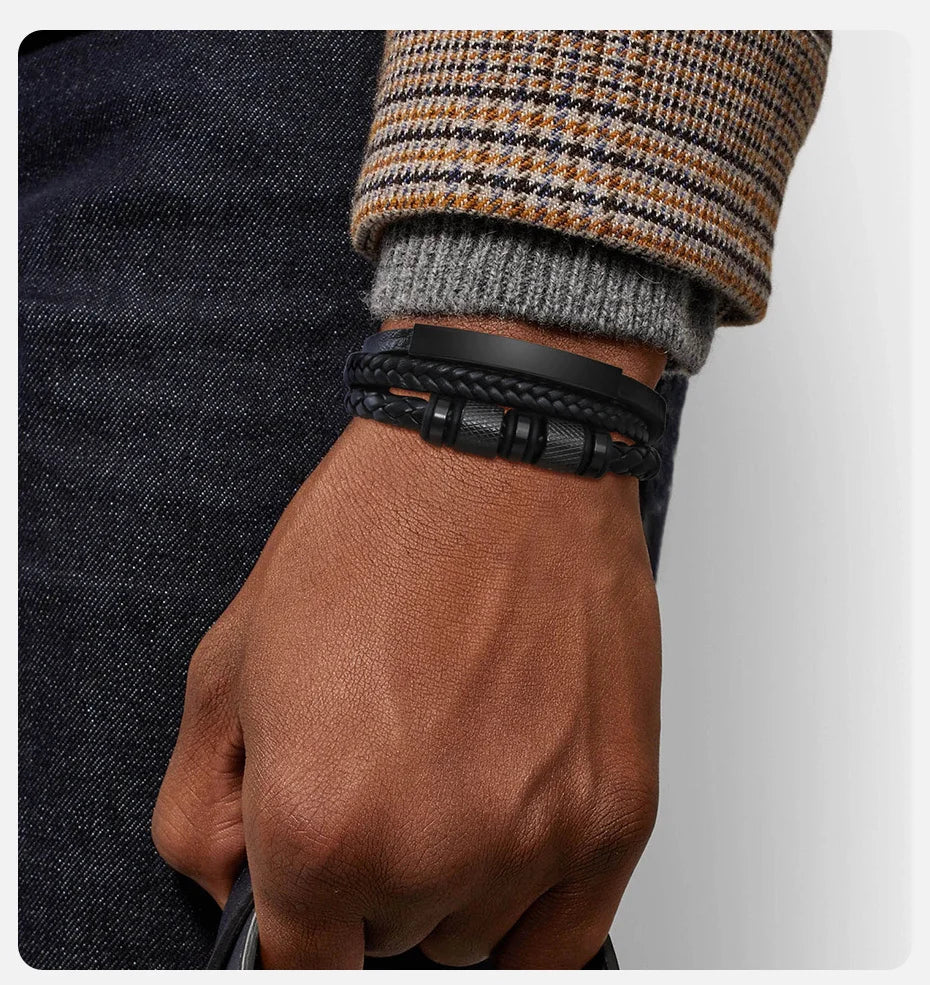 Nahaufnahme eines Mannes Handgelenks mit einem schwarzen geflochtenen Lederarmband, sichtbar gegen ein dunkles Hemd und einen