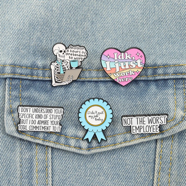 Enamel pin brooch featuring text like I just work here and Not the worst employee on a denim shirt