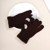 A pair of dark brown knit gloves with light gray accents resting on a white plate.
