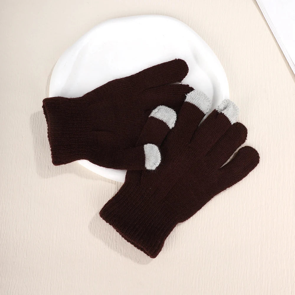 A pair of dark brown knit gloves with light gray accents resting on a white plate.