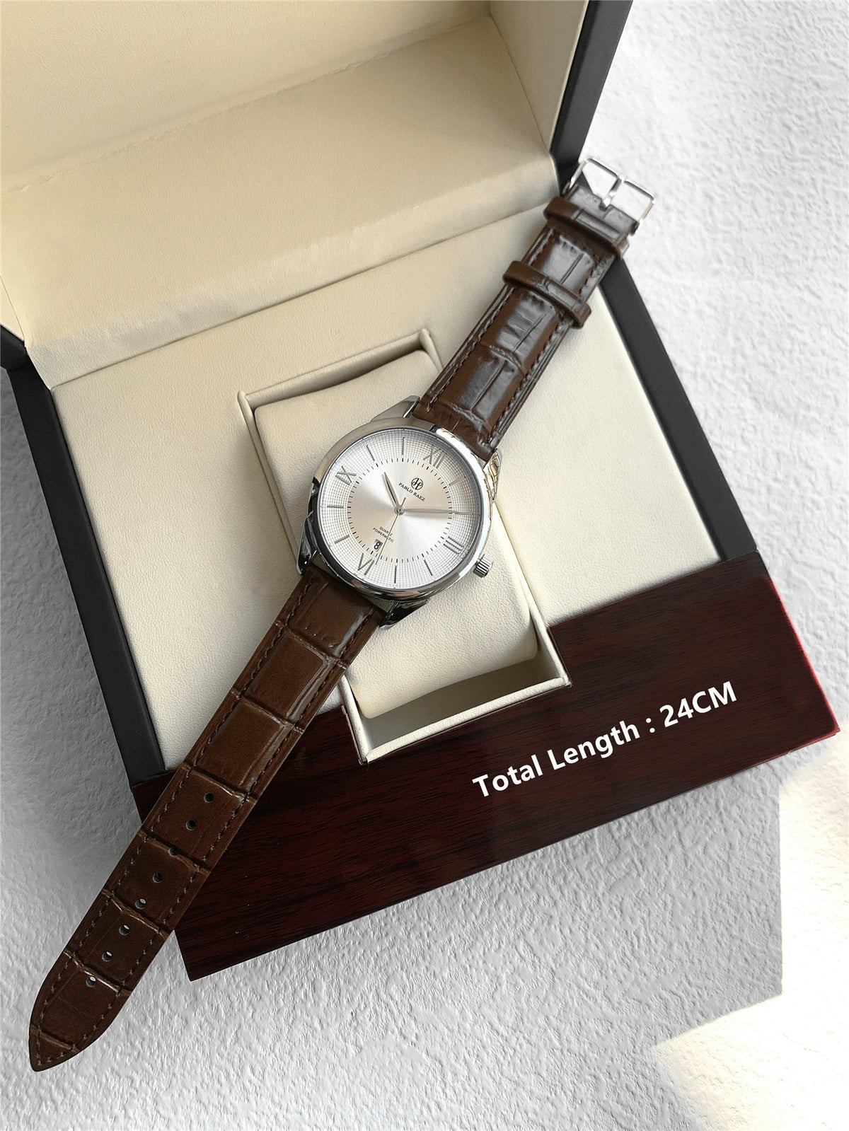 Une montre-bracelet en quartz de luxe pour homme avec un bracelet en cuir marron, présentée dans sa boîte.