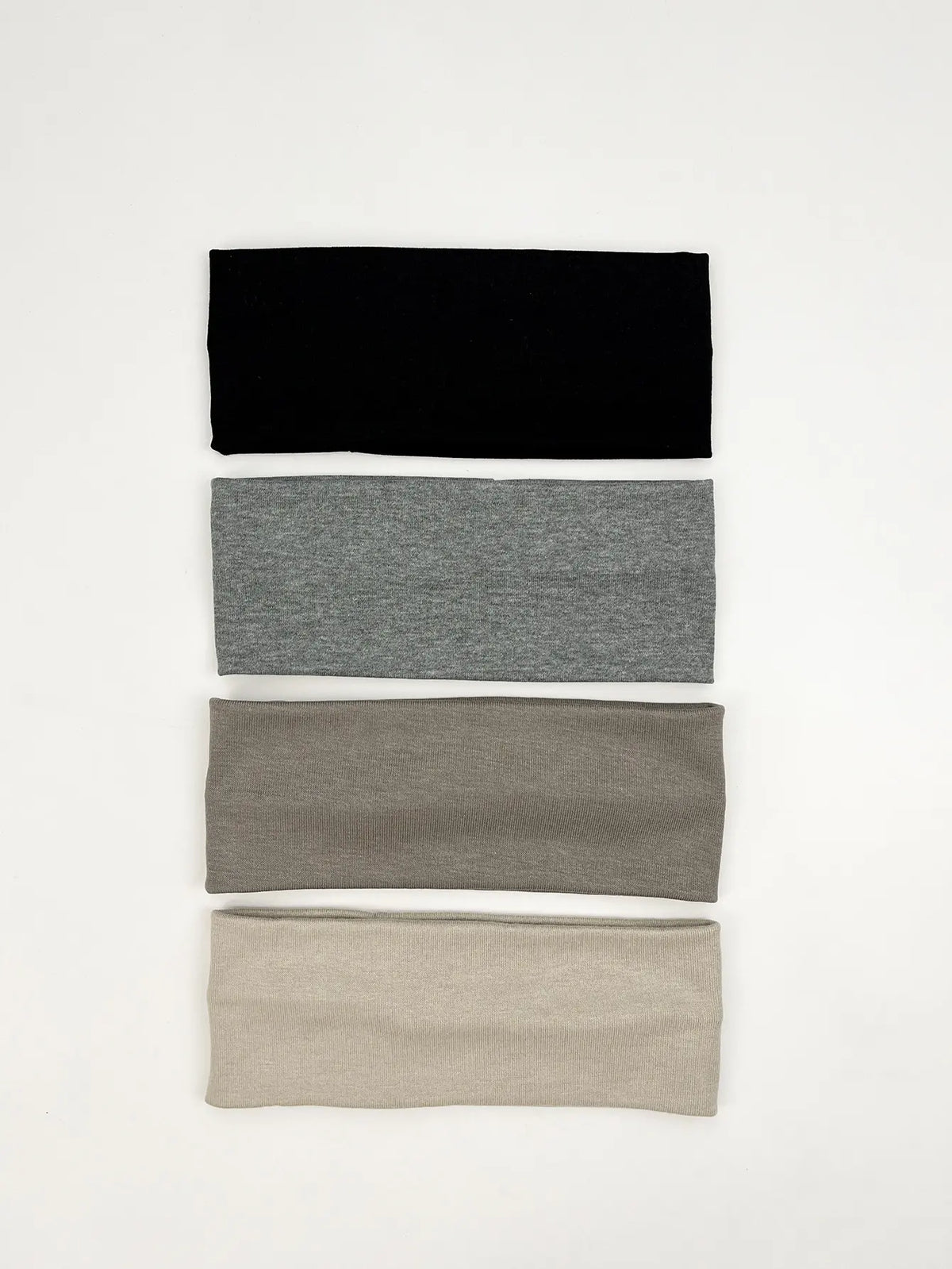 A set of four knitted hair bands in black, gray, taupe, and beige stacked vertically.