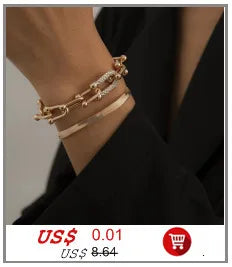 Gros plan du poignet d'une femme portant un collier imitation perles dorées.