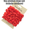 A pile of red satin hair scrunchies displayed on a cardboard tag.