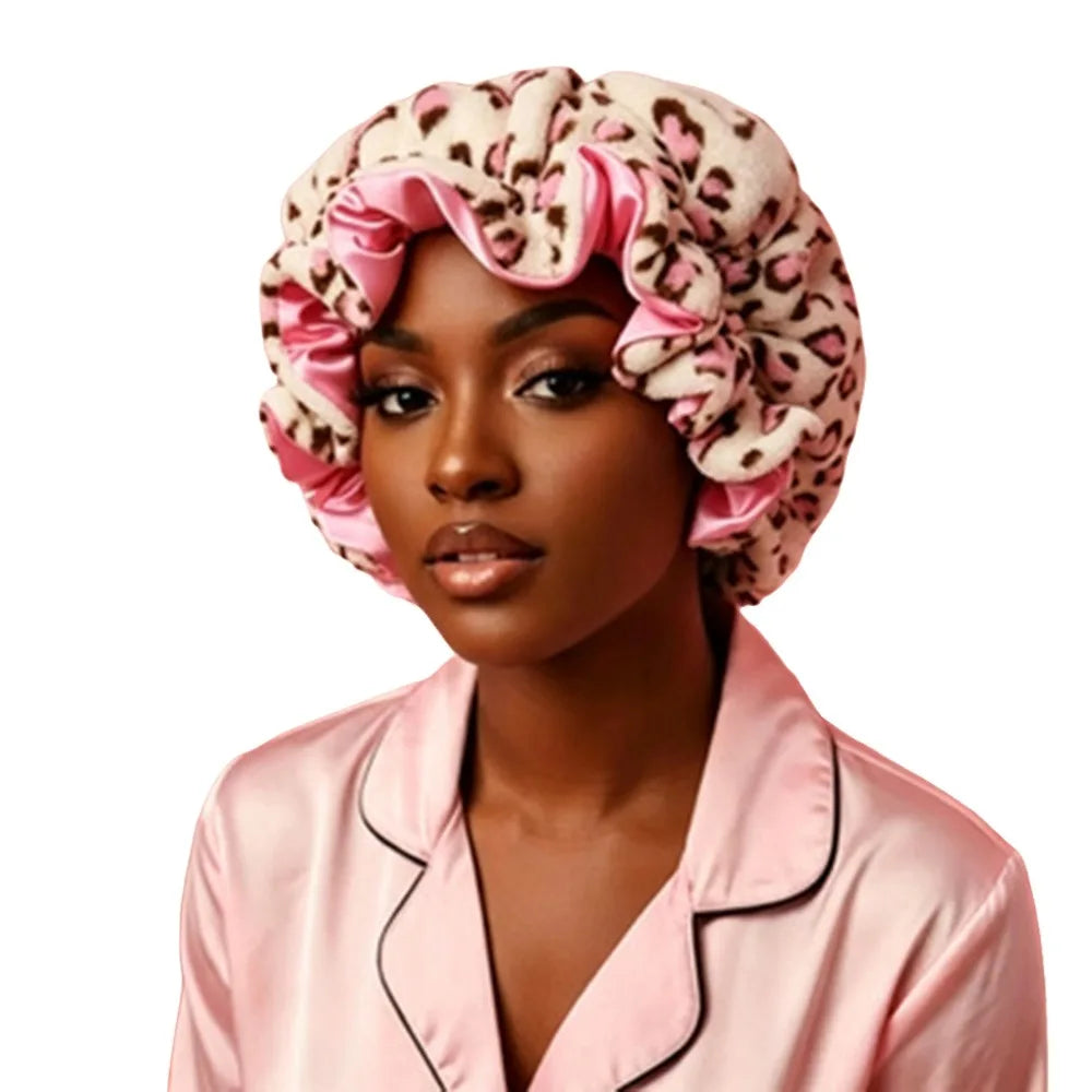 A woman wearing a pink leopard print hair drying cap with ruffled edges.