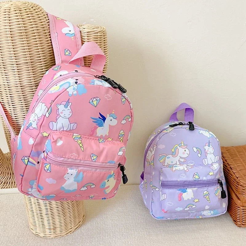A pink and purple unicorn dinosaur pattern kids backpack is displayed next to a woven basket.