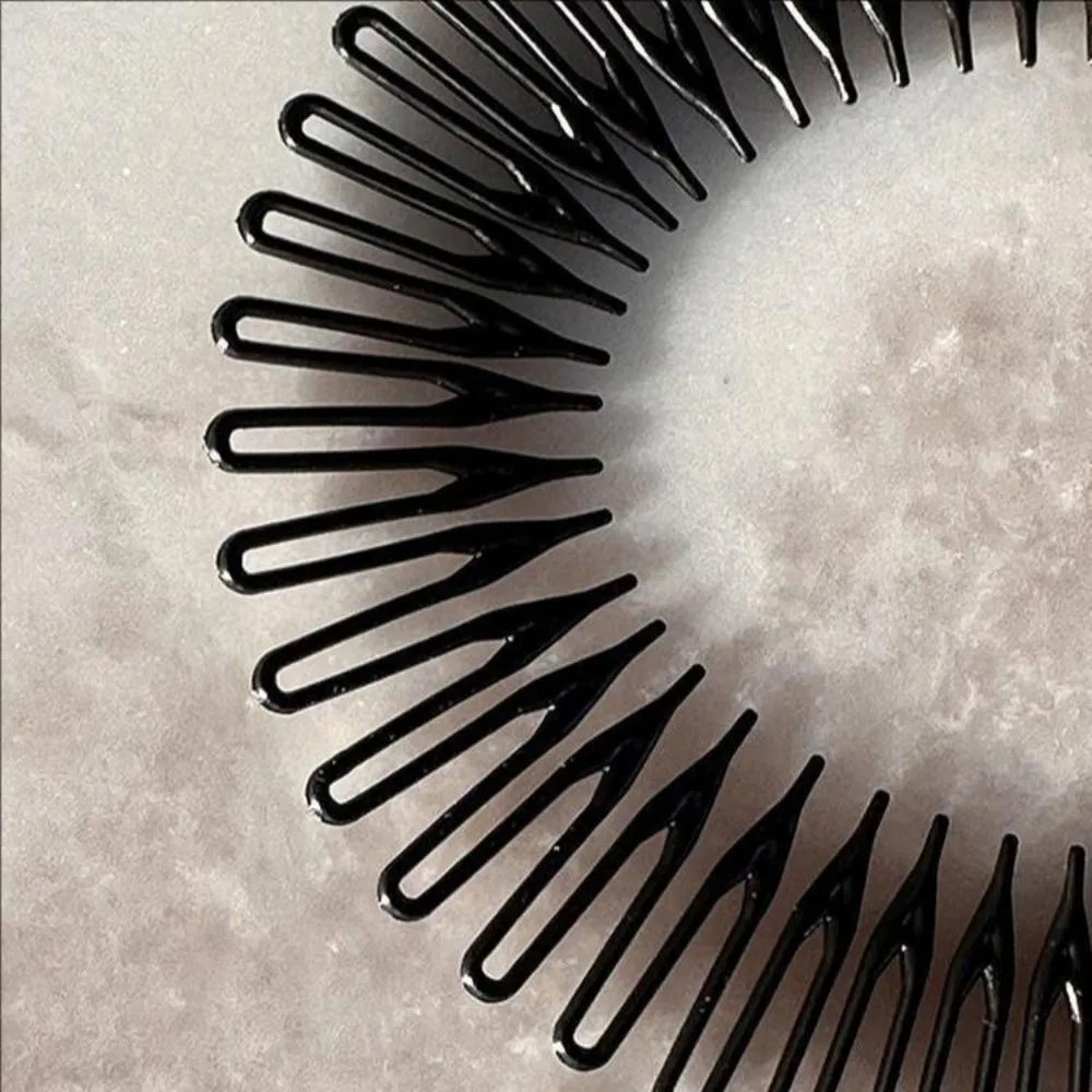 Gros plan d'un pack de deux pinces à cheveux en plastique noir et élastique sur une surface claire.
