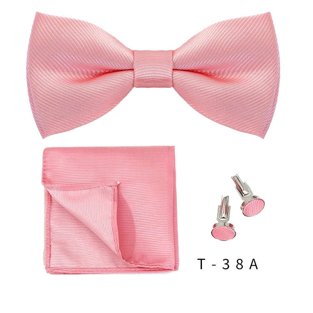 Pink knitted bow tie and cufflinks set displayed on a white background.