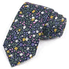 Une cravate bleu foncé avec un motif floral élégant aux couleurs violet, jaune et blanc.