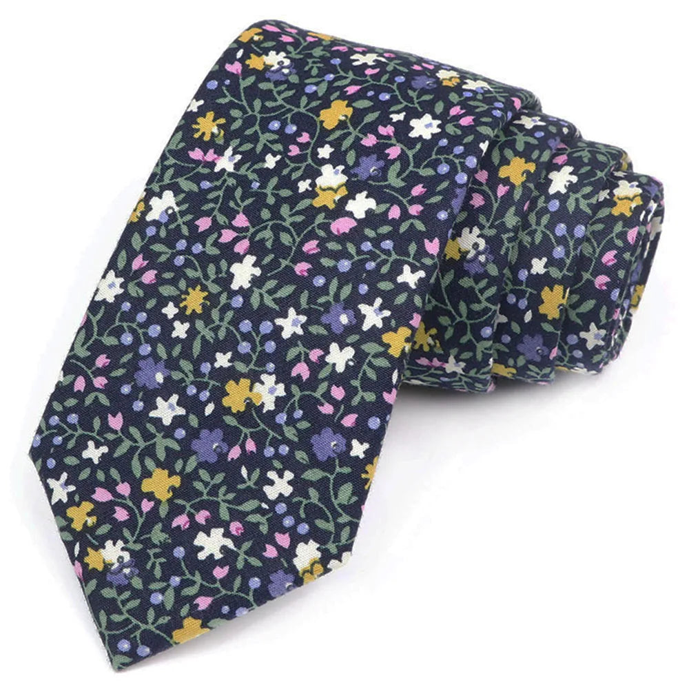 Une cravate bleu foncé avec un motif floral élégant aux couleurs violet, jaune et blanc.