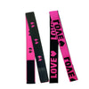 Two adjustable elastic bands for wig edges, one black with pink flowers and one bright pink with black hearts.