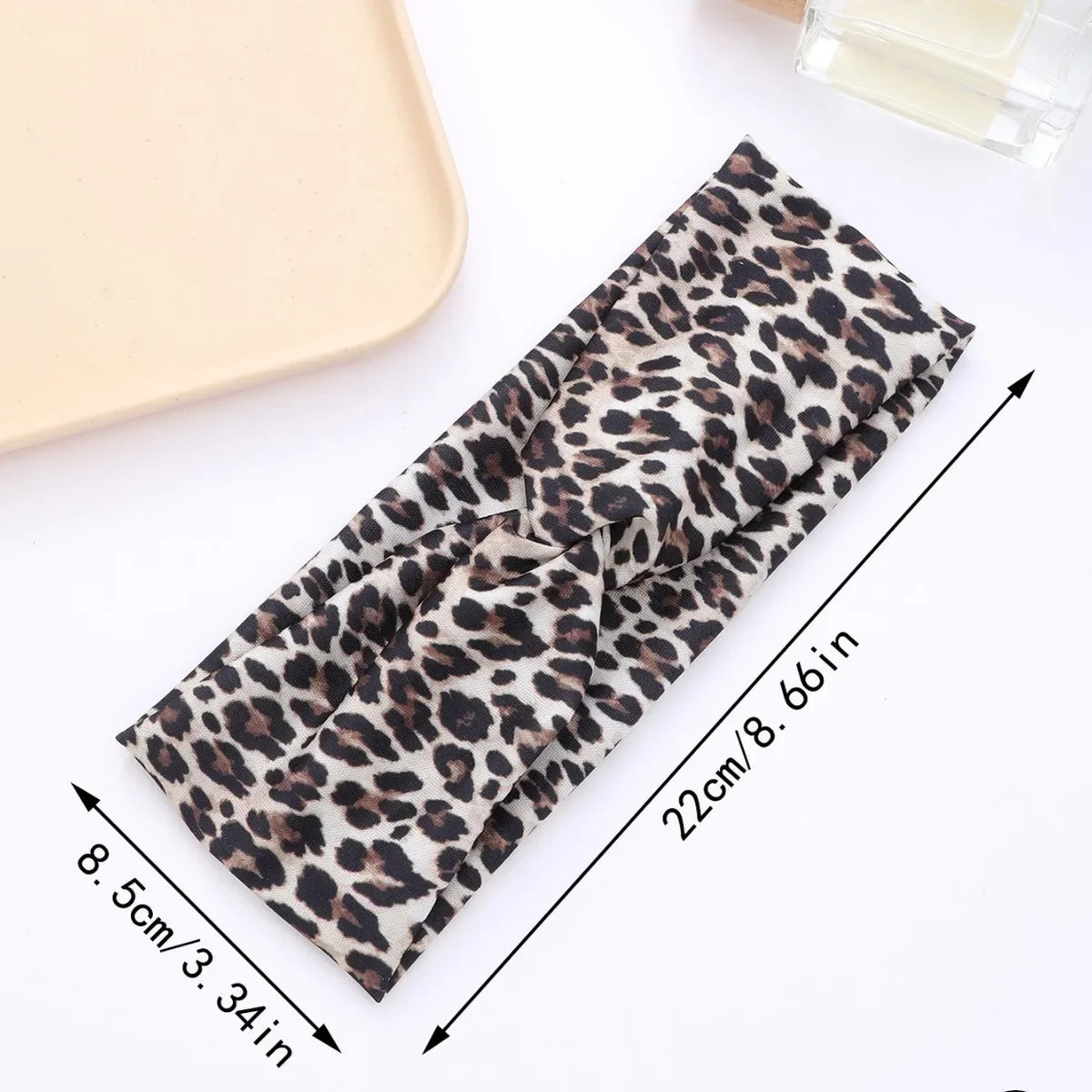 A black and brown leopard print fabric headband is shown laid out with measurements.