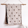A beige pashmina shawl featuring a floral print of small bees and dried foliage.