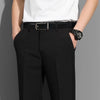 Un homme en costume noir et chemise blanche avec une ceinture en cuir noire et une montre.