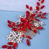 A delicate red crystal and pearl hair comb accessory with gold wire detailing.