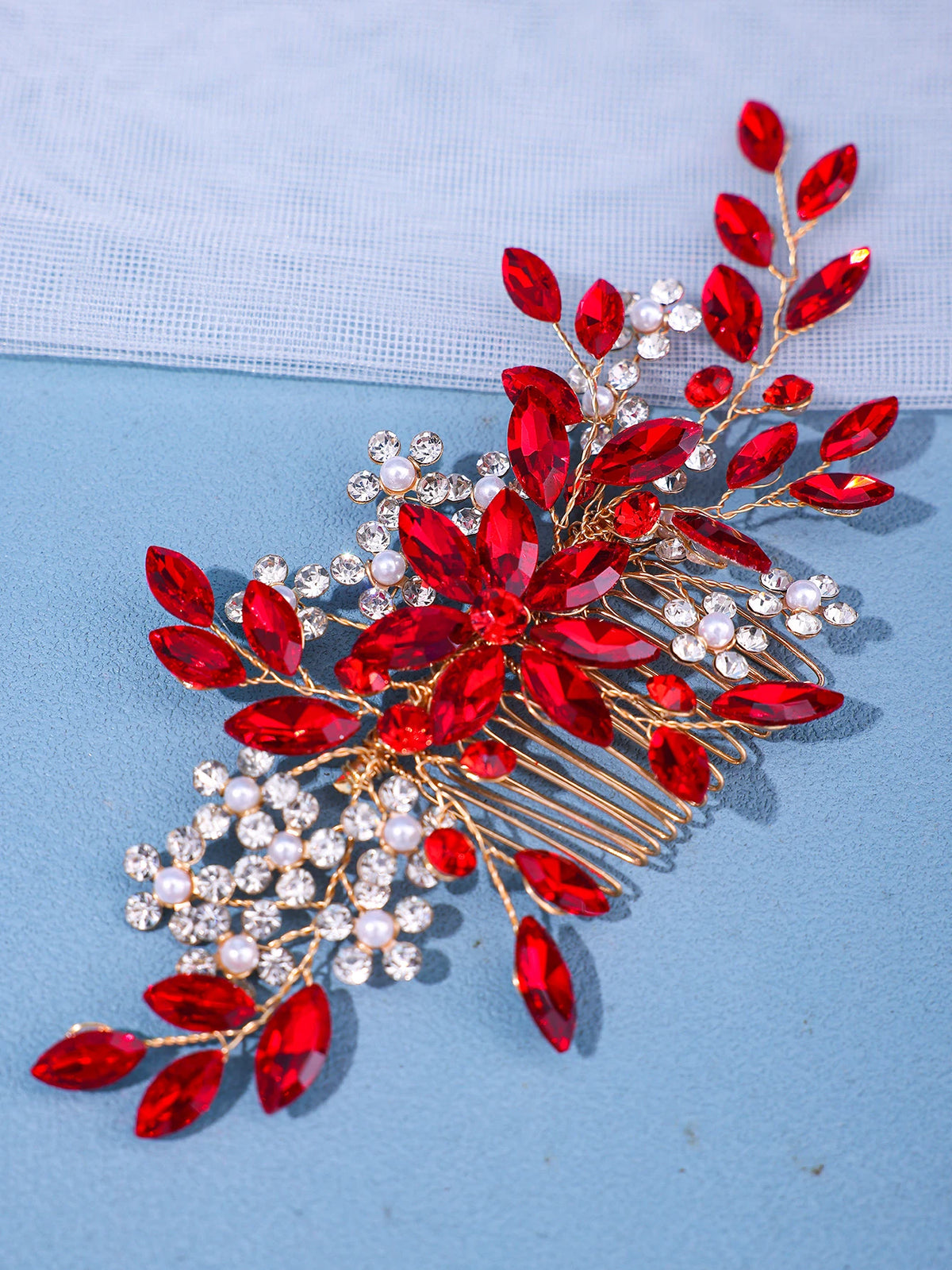 A delicate red crystal and pearl hair comb accessory with gold wire detailing.