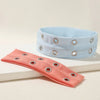 A light blue metal hollow headband and a coral pink fabric headband are displayed on a white surface.