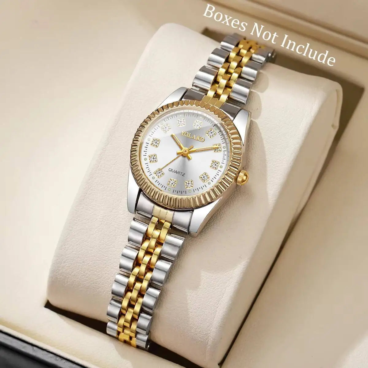 A silver and gold rhinestone quartz wristwatch is displayed on a light-colored surface.