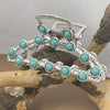 Silver metal hair claw clips decorated with turquoise beads resting on a natural wood branch.