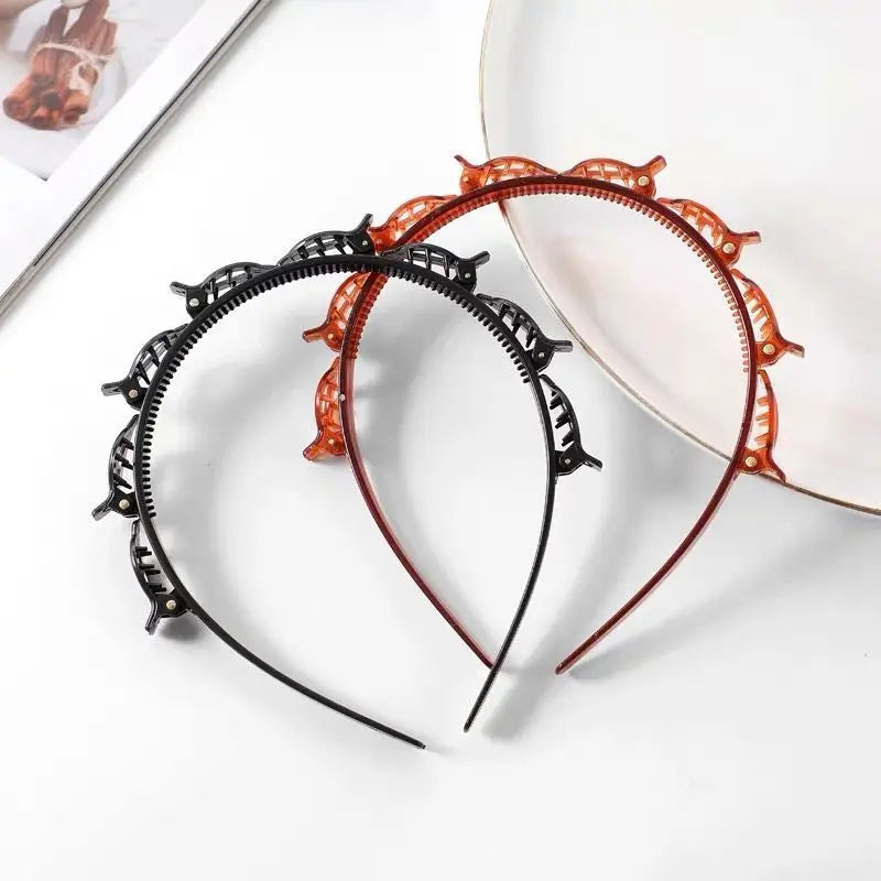 A black braided hair headband clip with orange accents is displayed on a white background next to a plate.