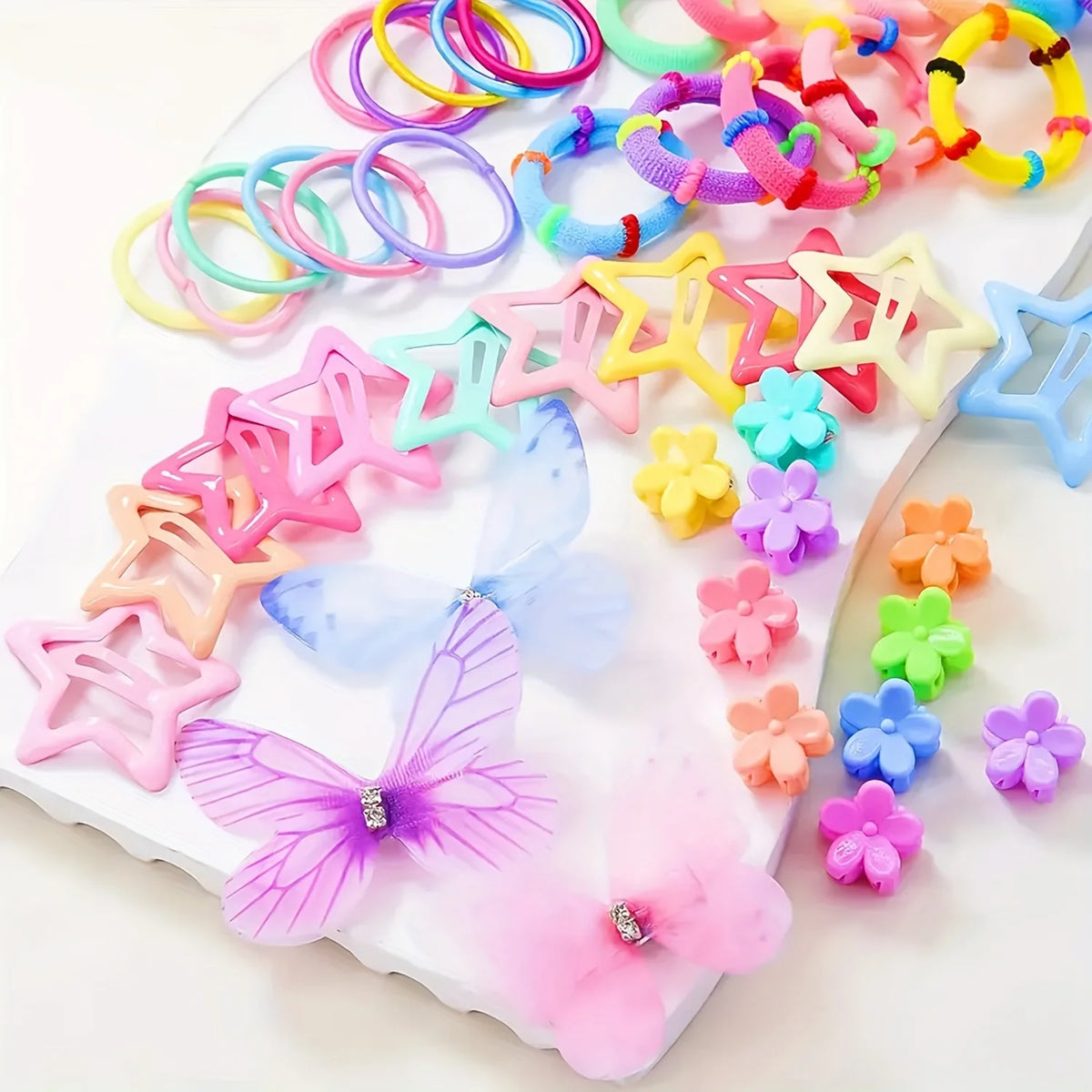 A collection of colorful decorative hair accessories including rings, star shapes, and butterfly clips on a white surface.