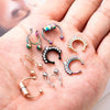 A hand holds a collection of magnetic stainless steel septum rings in various finishes and styles.