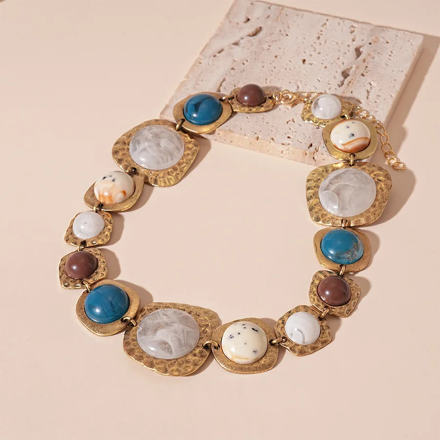 Boho gold plated resin statement choker necklace featuring round beads in blue, white, and brown tones