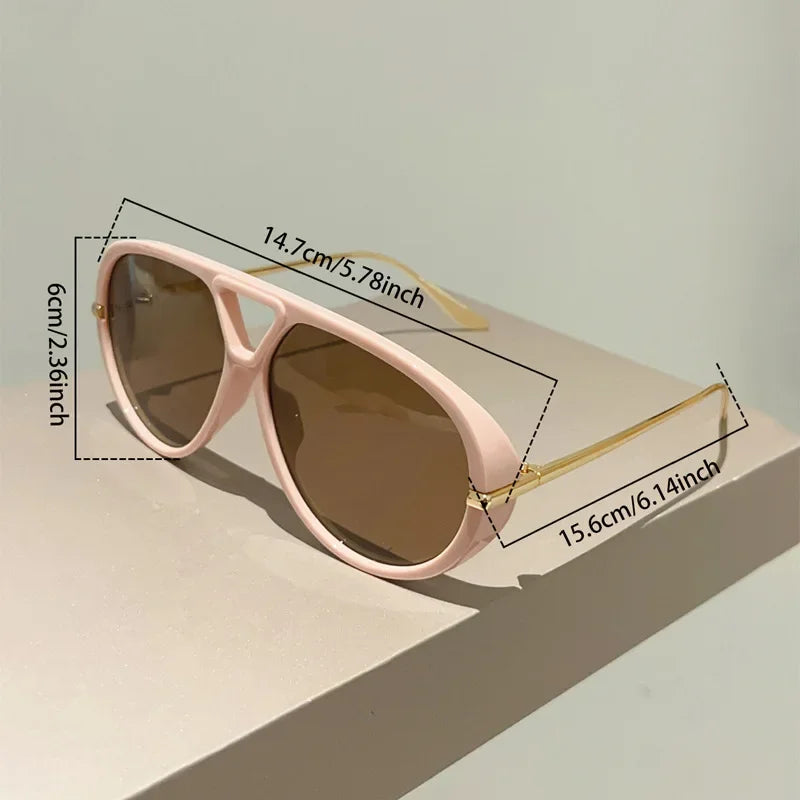 Pink aviator style sunglasses with gold accents shown on a light surface.