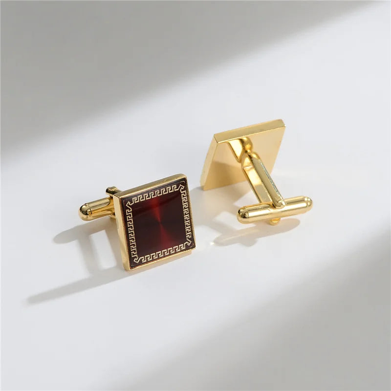 Elegant gold cufflinks featuring a square design with a dark red stone and a rectangular bar clip.