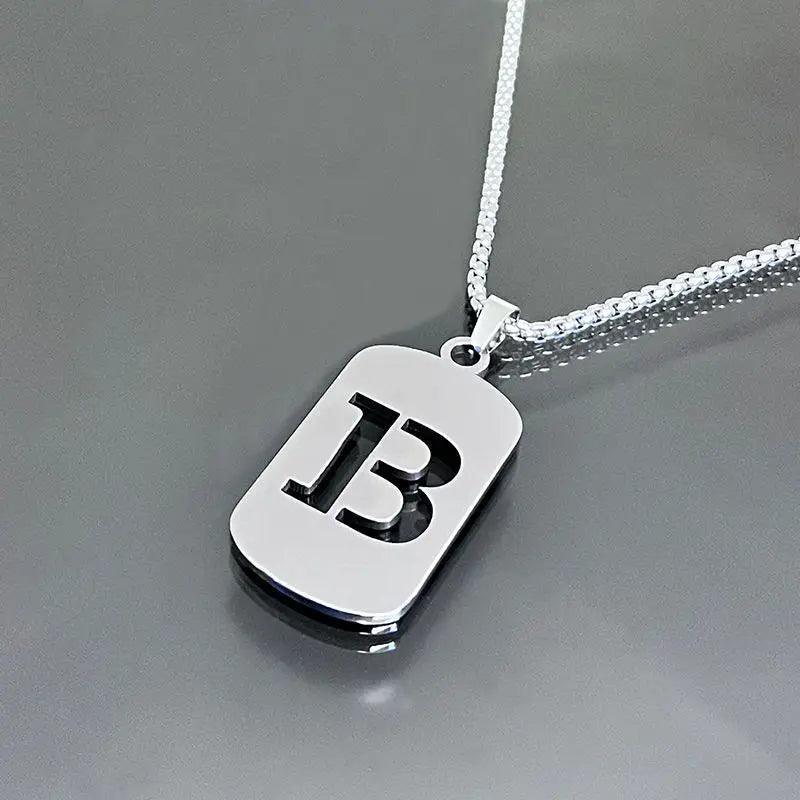 A silver stainless steel pendant necklace featuring a large initial letter B on a chain.