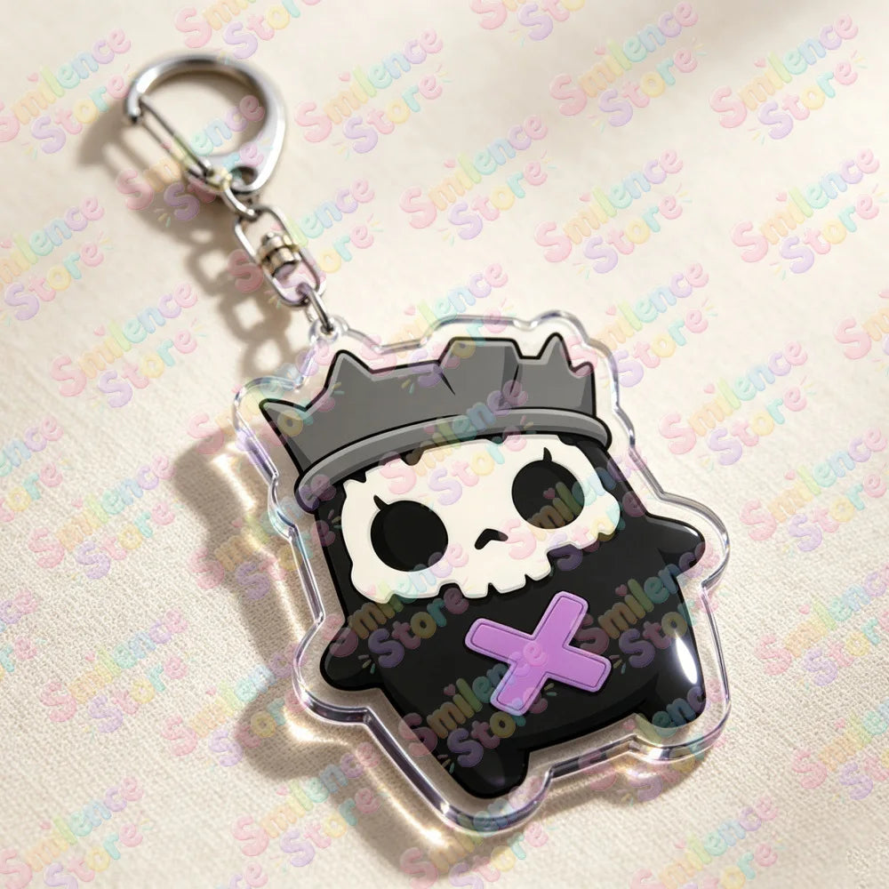 A clear acrylic keychain featuring a black skull and crossbones design with a crown silhouette.