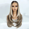 A model wears a layered straight synthetic lace front wig with long blonde hair and striking eyes.