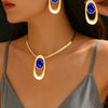 Gold and blue gemstone necklace set featuring an oval pendant and matching hoop earrings