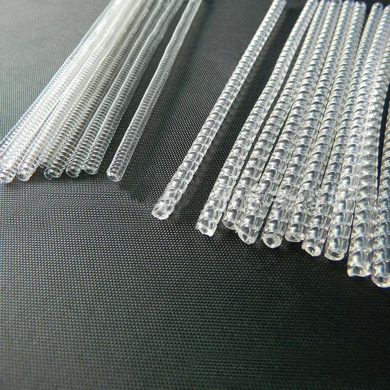A set of clear, thin plastic ring size adjusters arranged in a row on a dark surface.