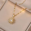Collier en or avec pendentif de fleur zircon en éclat solaire, présenté sur une boîte de couleur claire.