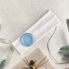 A white fabric headband with a light blue wind dot detail is displayed on a light background.