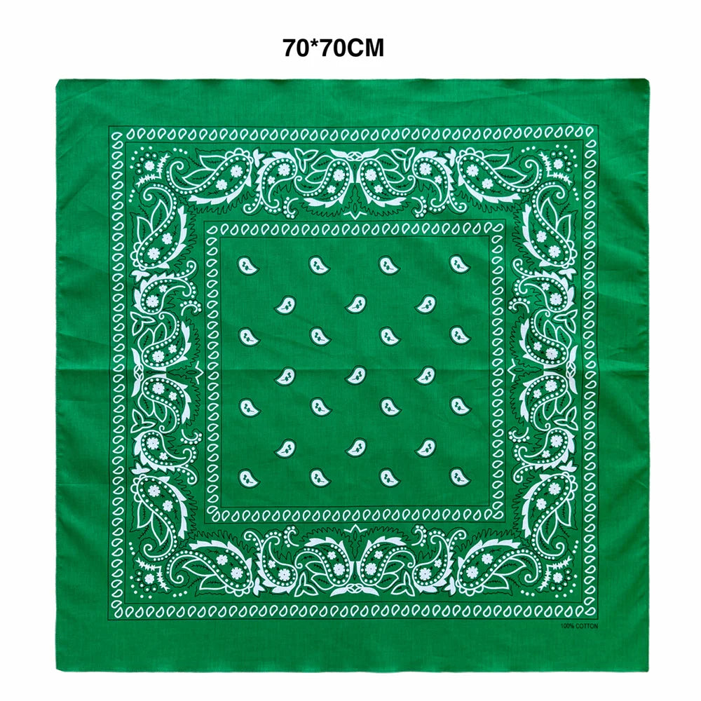 A green fabric square featuring white paisley embroidery and a central square design.
