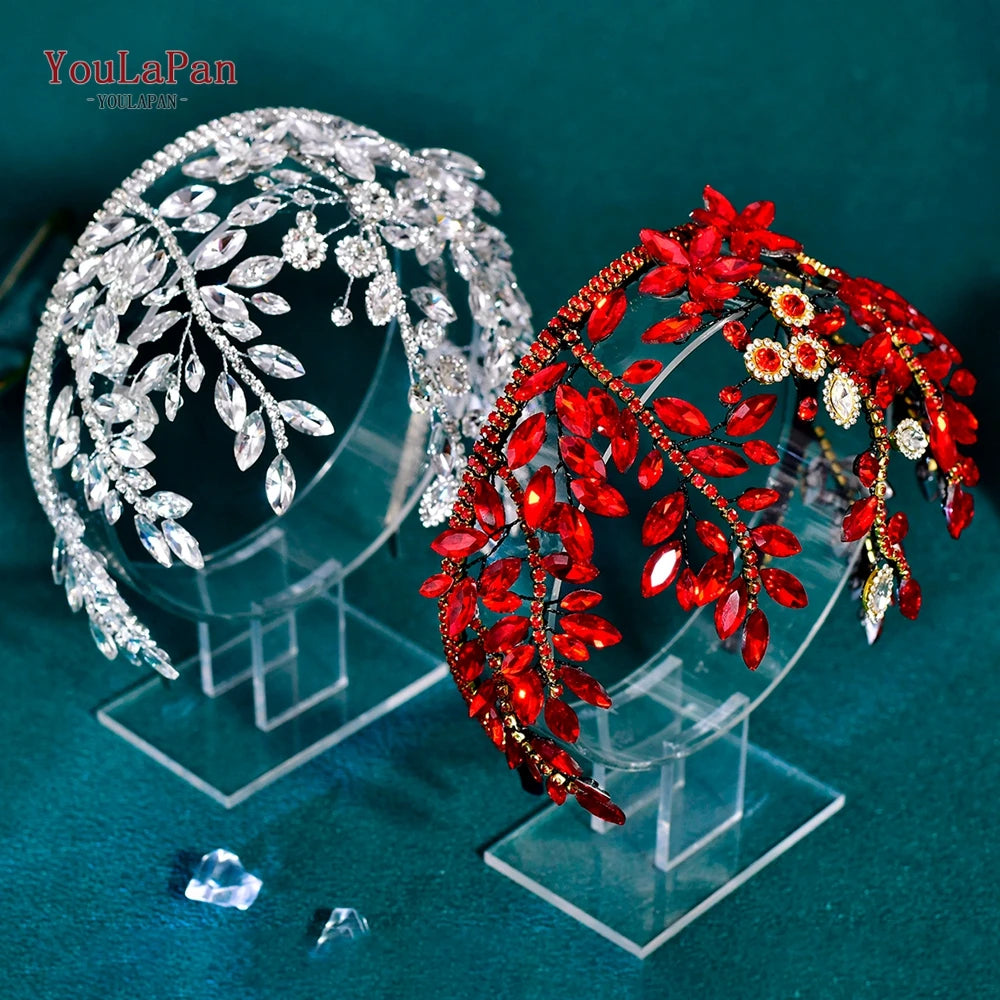 A sparkling rhinestone bridal hair hoop and a branch of red berries displayed on clear stands.