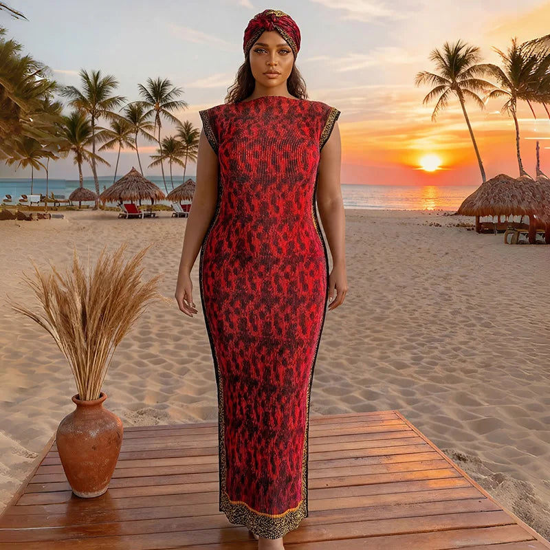 A plus size model wearing a red and black African silk printed dress standing on a wooden deck with a tropical sunset backgro