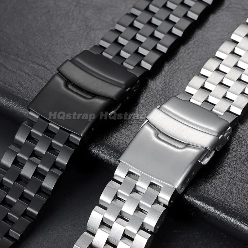 A close-up of an adjustable stainless steel watch band shown in black and silver finishes.