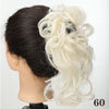 A woman's dark hair is styled in a messy blonde synthetic hairpiece bun