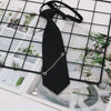 A black classic chain necktie accessory is displayed against a grid background of floral and natural imagery.