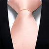 Ein rosa Seiden-Krawattenknoten, präsentiert vor einer schwarzen Sakkojacke.