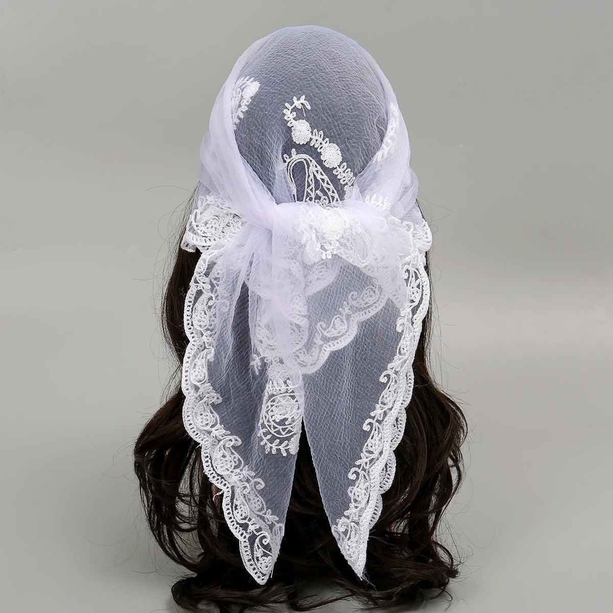White floral embroidered lace bandana headscarf tied around dark hair