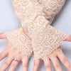 Close-up of beige lace anti-sunburn arm sleeves worn on a hand.