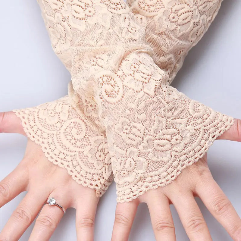Close-up of beige lace anti-sunburn arm sleeves worn on a hand.