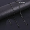 A close-up of a black stainless steel Cuban link necklace with a 4mm chain, displayed on a dark leather surface.